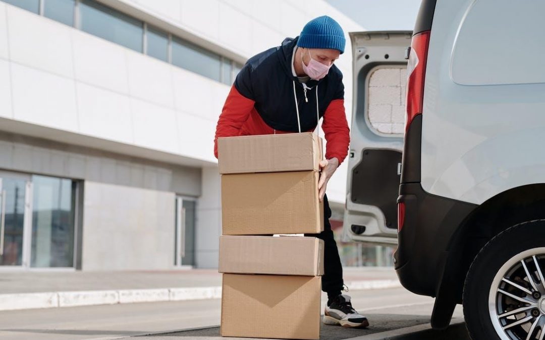 A delivery man unloading boxes from his van