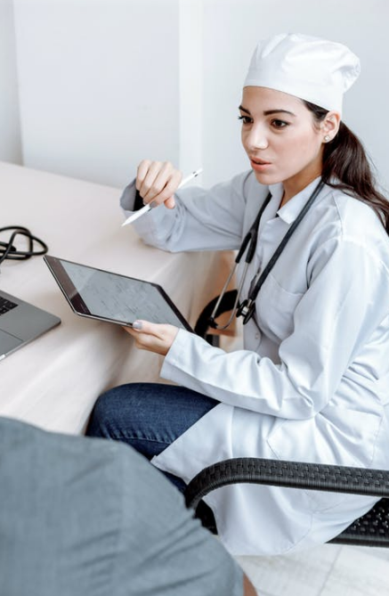 A doctor is talking to a patient and using an iPad